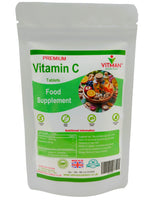 A white stand-up pouch of Vitman Nutrition Premium Vitamin C Tablets Food Supplement, featuring a green and white label with a colorful fruit and vegetable illustration.